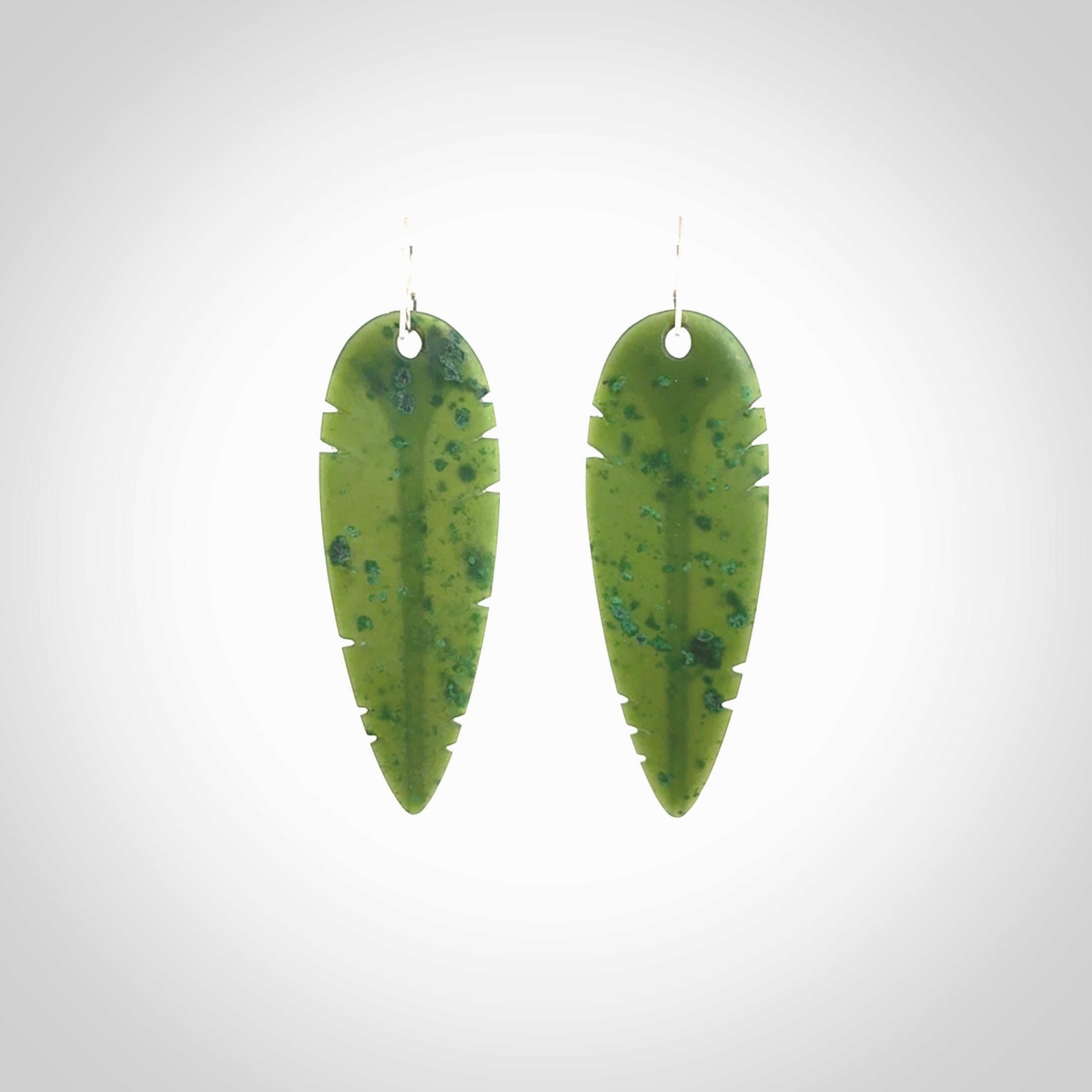 This picture shows British Columbian jade kaka feather earrings with sterling silver hooks. Hand made unique and contemporary feather earrings by Kerry Thompson. Hand carved here in New Zealand from British Columbian Jade. One pair only.