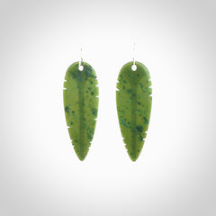 This picture shows British Columbian jade kaka feather earrings with sterling silver hooks. Hand made unique and contemporary feather earrings by Kerry Thompson. Hand carved here in New Zealand from British Columbian Jade. One pair only.