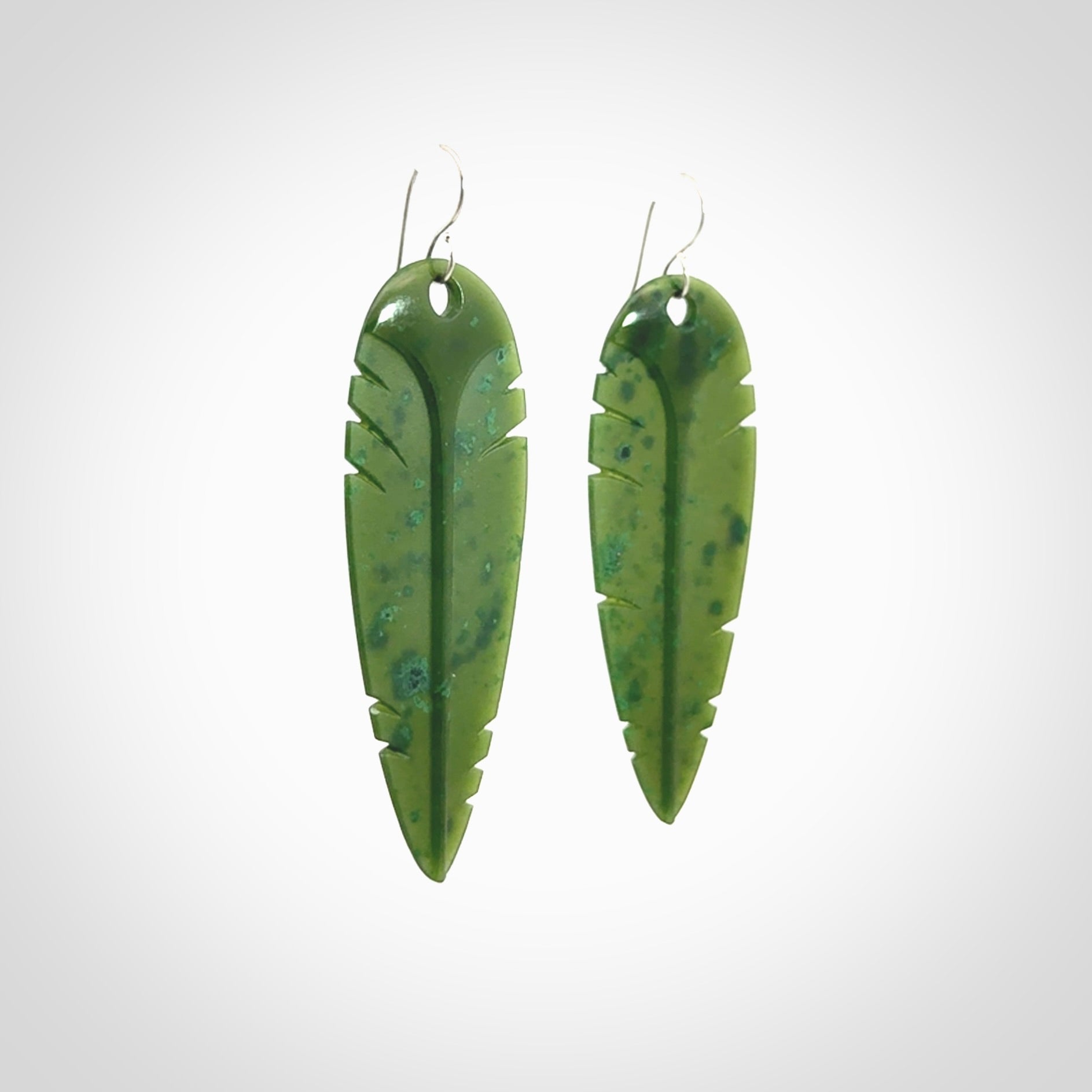 This picture shows British Columbian jade kaka feather earrings with sterling silver hooks. Hand made unique and contemporary feather earrings by Kerry Thompson. Hand carved here in New Zealand from British Columbian Jade. One pair only.