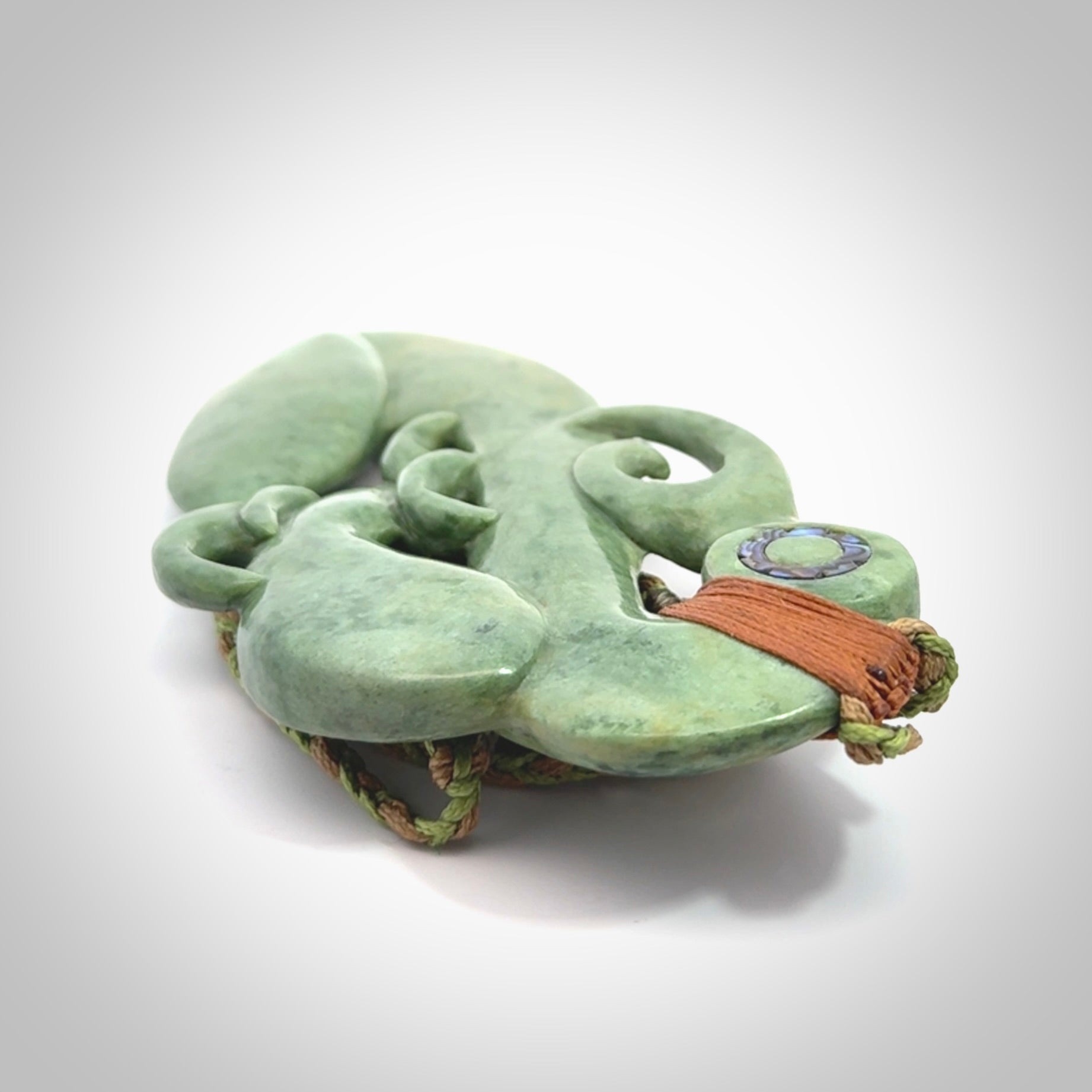 This picture shows a large traditional manaia pendant carved in New Zealand Jade.