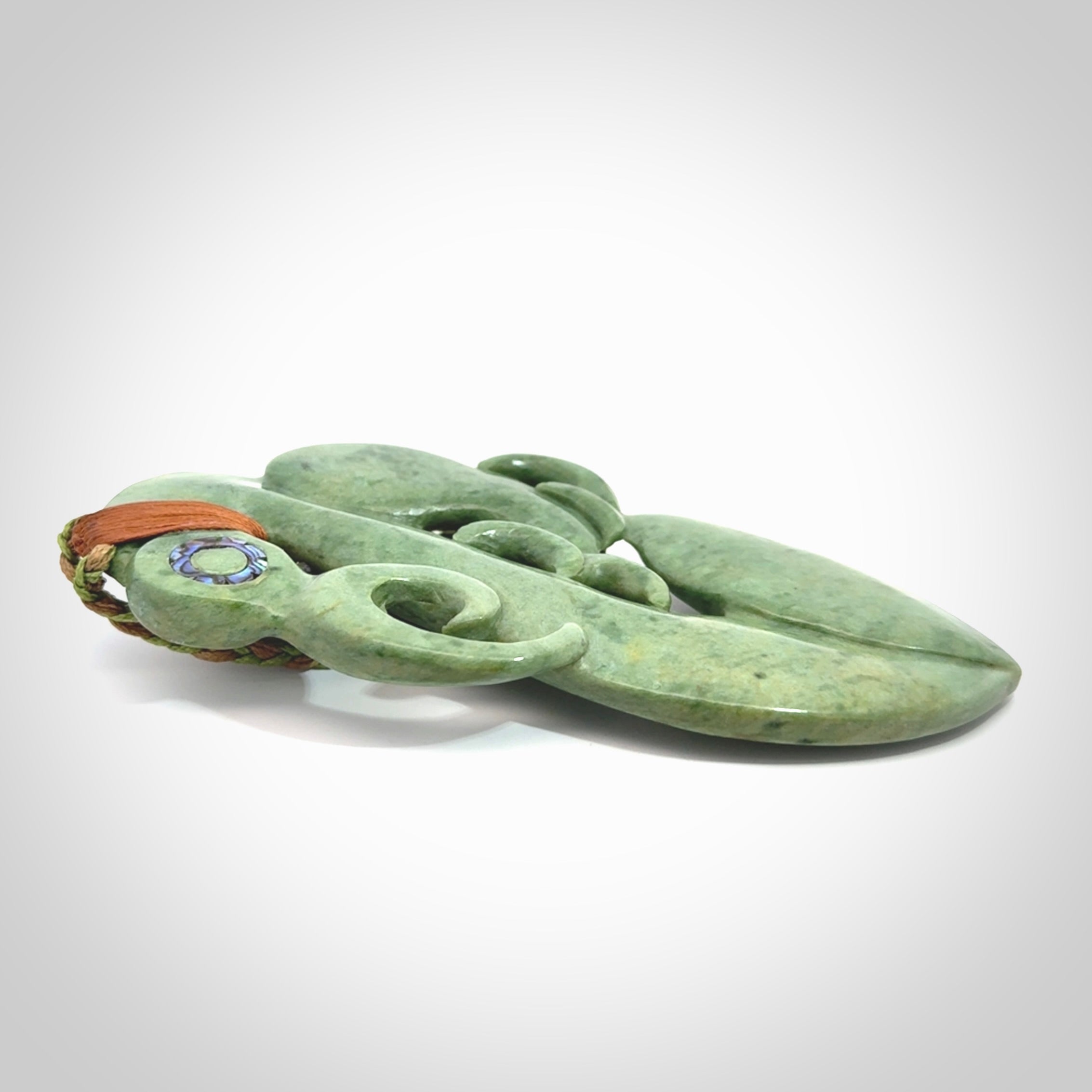 This picture shows a large traditional manaia pendant carved in New Zealand Jade.