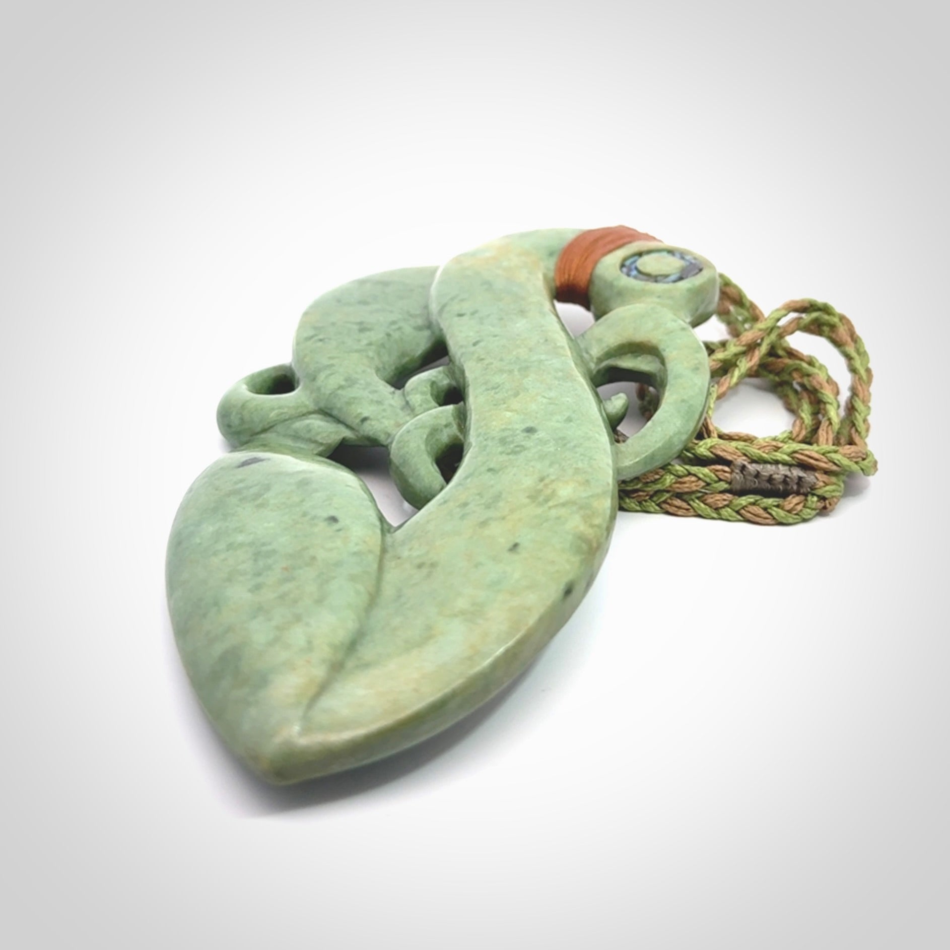 This picture shows a large traditional manaia pendant carved in New Zealand Jade.