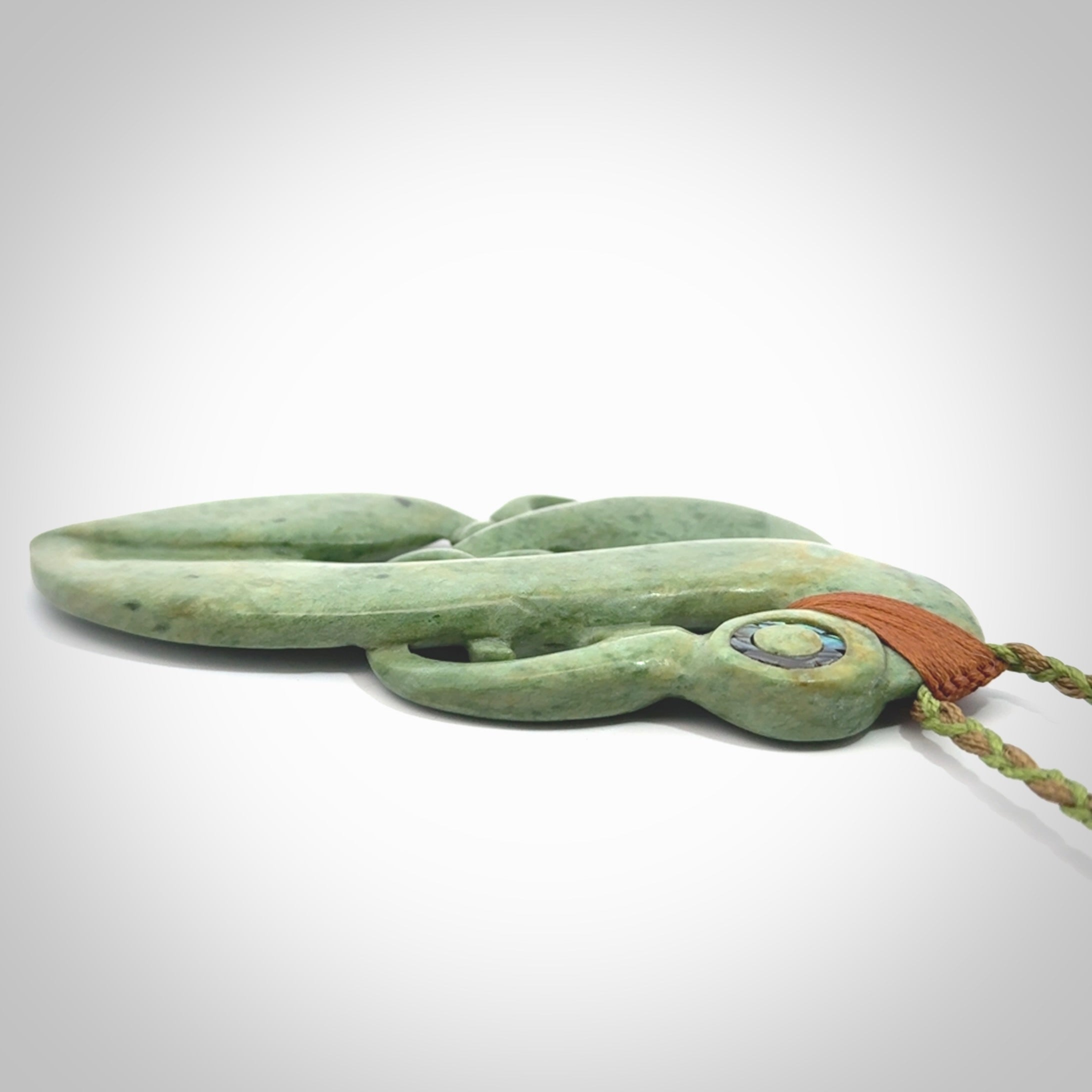 This picture shows a large traditional manaia pendant carved in New Zealand Jade.
