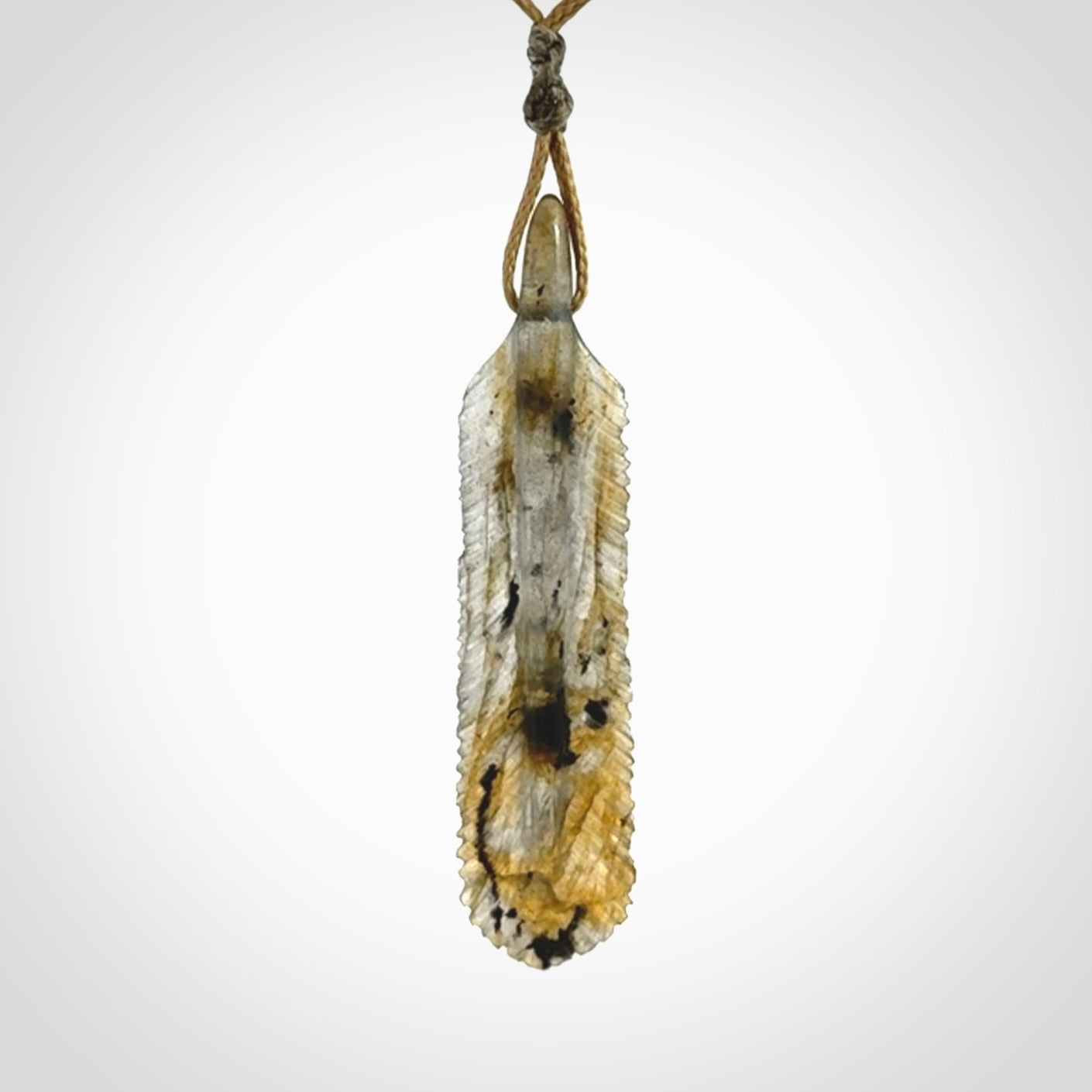This is a hand carved feather pendant made from Labradorite stone.