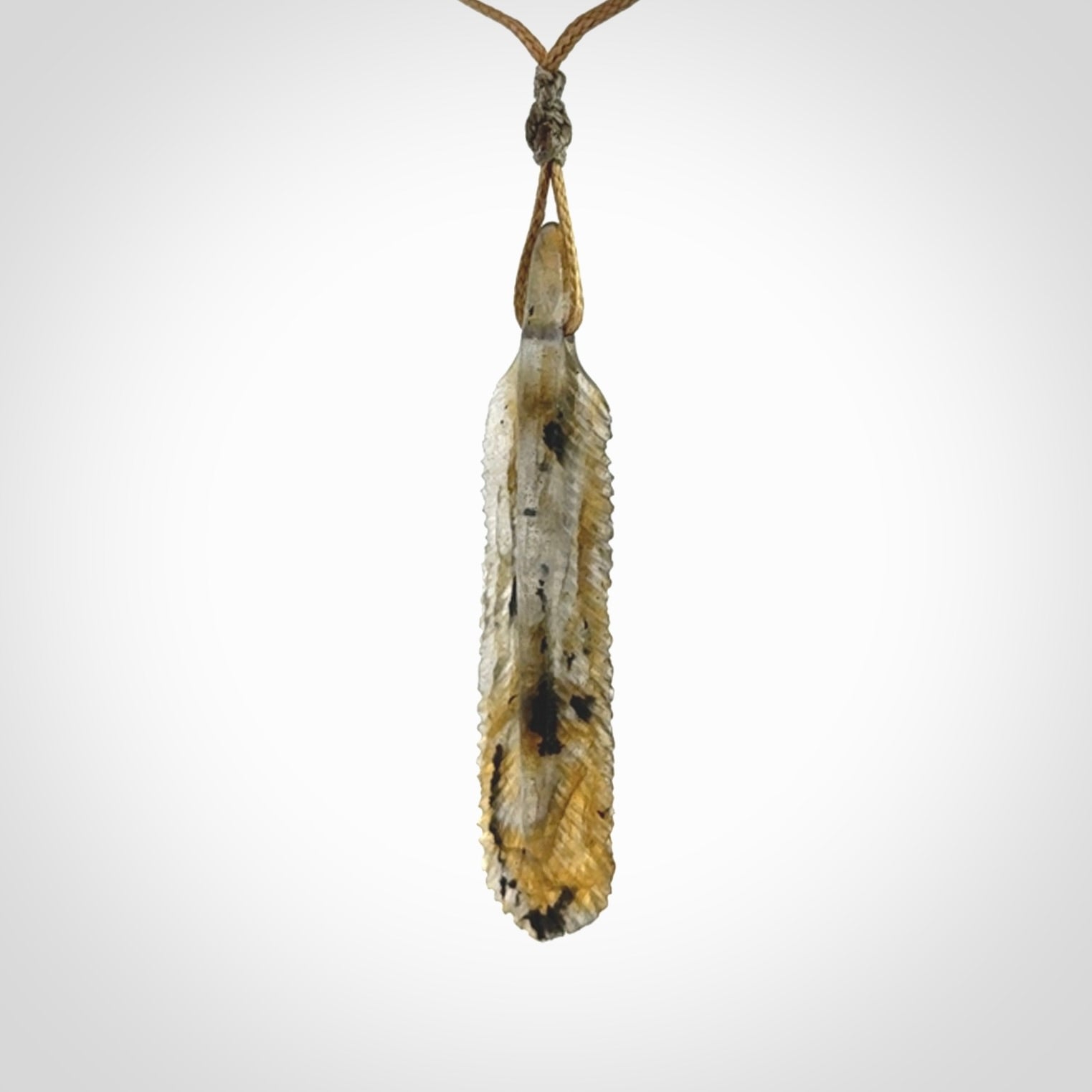 This is a hand carved feather pendant made from Labradorite stone.