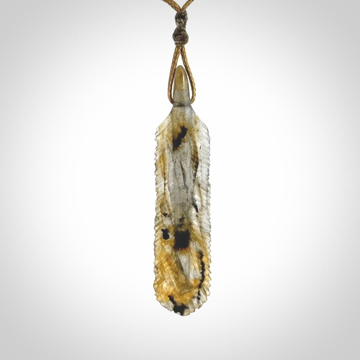 This is a hand carved feather pendant made from Labradorite stone.