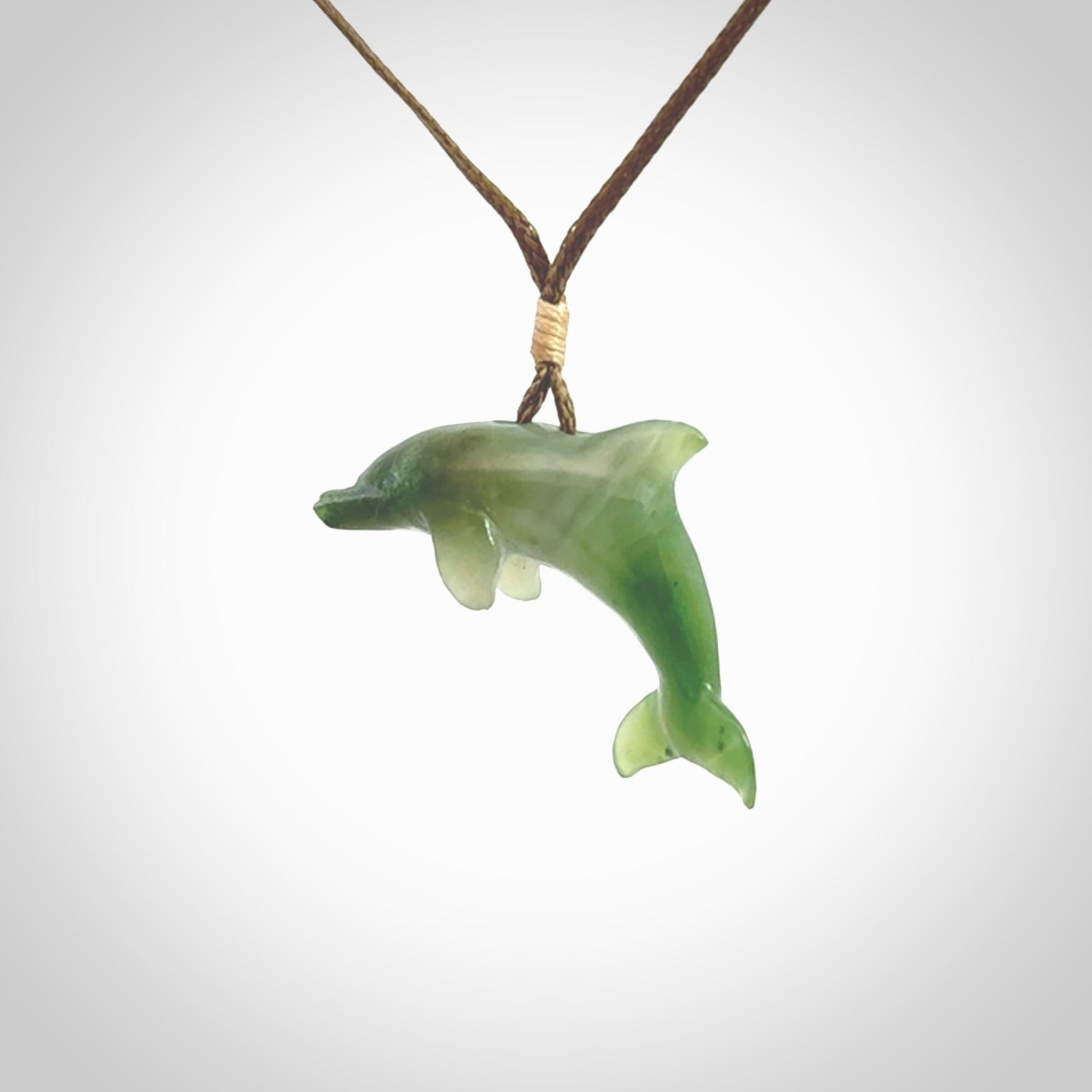 This is a gorgeous little dolphin pendant carved in green nephrite jade. The cord is fine and length adjustable so you can position the little jade dolphin where it suits you best. Shipping is free worldwide.
