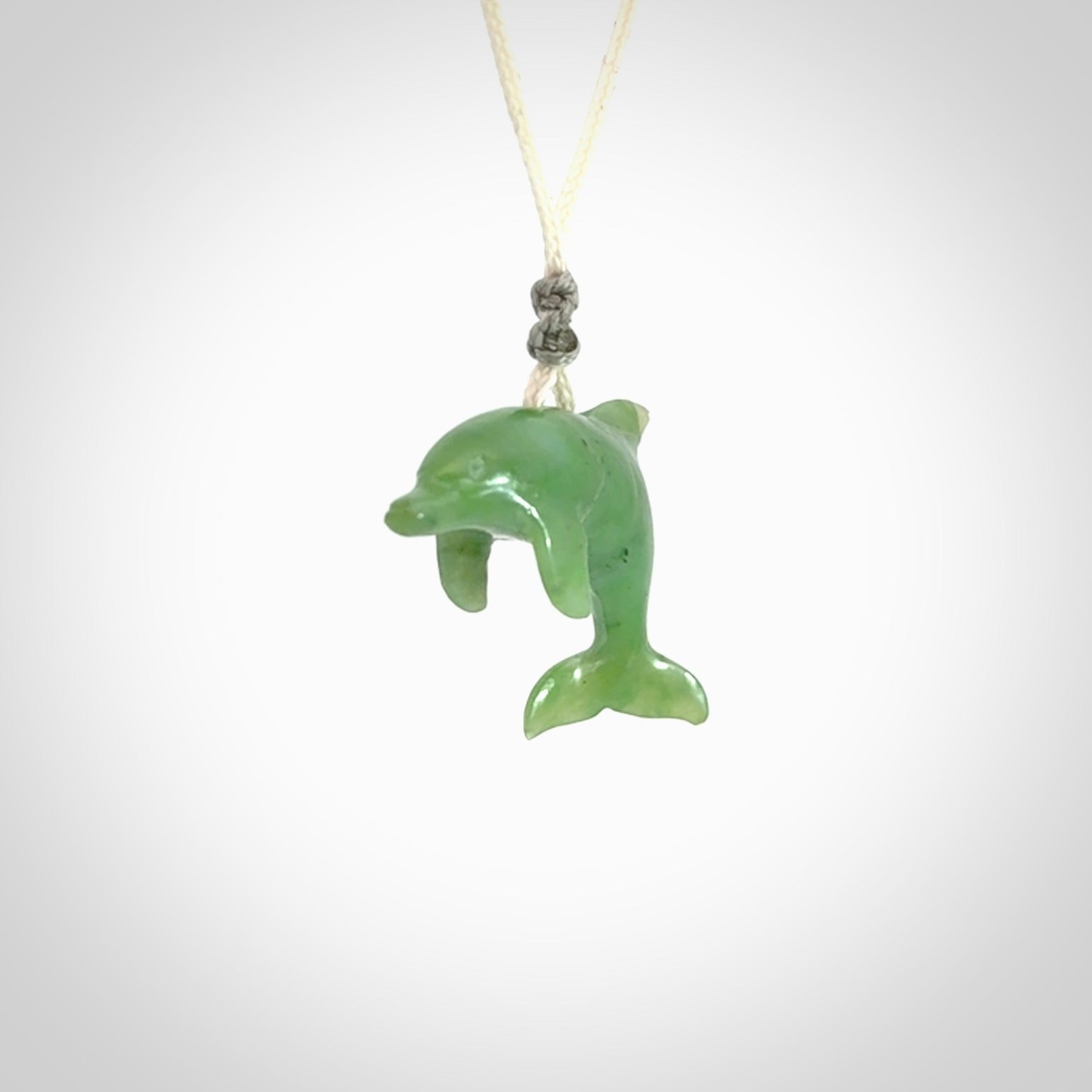 This is a gorgeous little dolphin pendant carved in green nephrite jade. The cord is fine and length adjustable so you can position the little jade dolphin where it suits you best. Shipping is free worldwide.