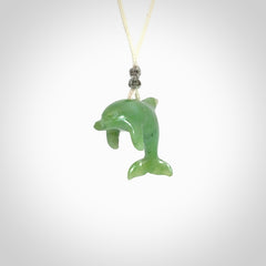 This is a gorgeous little dolphin pendant carved in green nephrite jade. The cord is fine and length adjustable so you can position the little jade dolphin where it suits you best. Shipping is free worldwide.