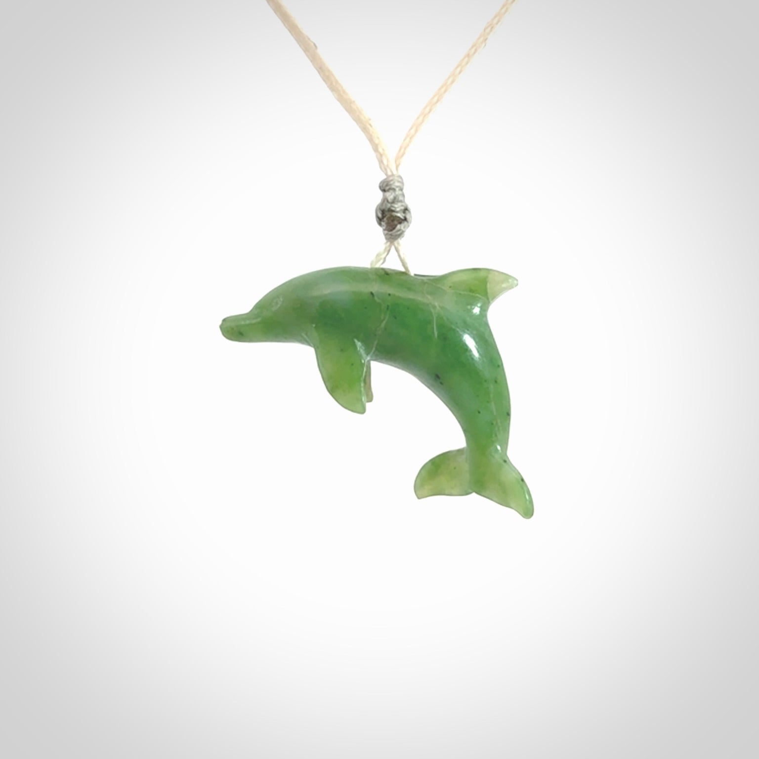 This is a gorgeous little dolphin pendant carved in green nephrite jade. The cord is fine and length adjustable so you can position the little jade dolphin where it suits you best. Shipping is free worldwide.