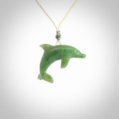 This is a gorgeous little dolphin pendant carved in green nephrite jade. The cord is fine and length adjustable so you can position the little jade dolphin where it suits you best. Shipping is free worldwide.