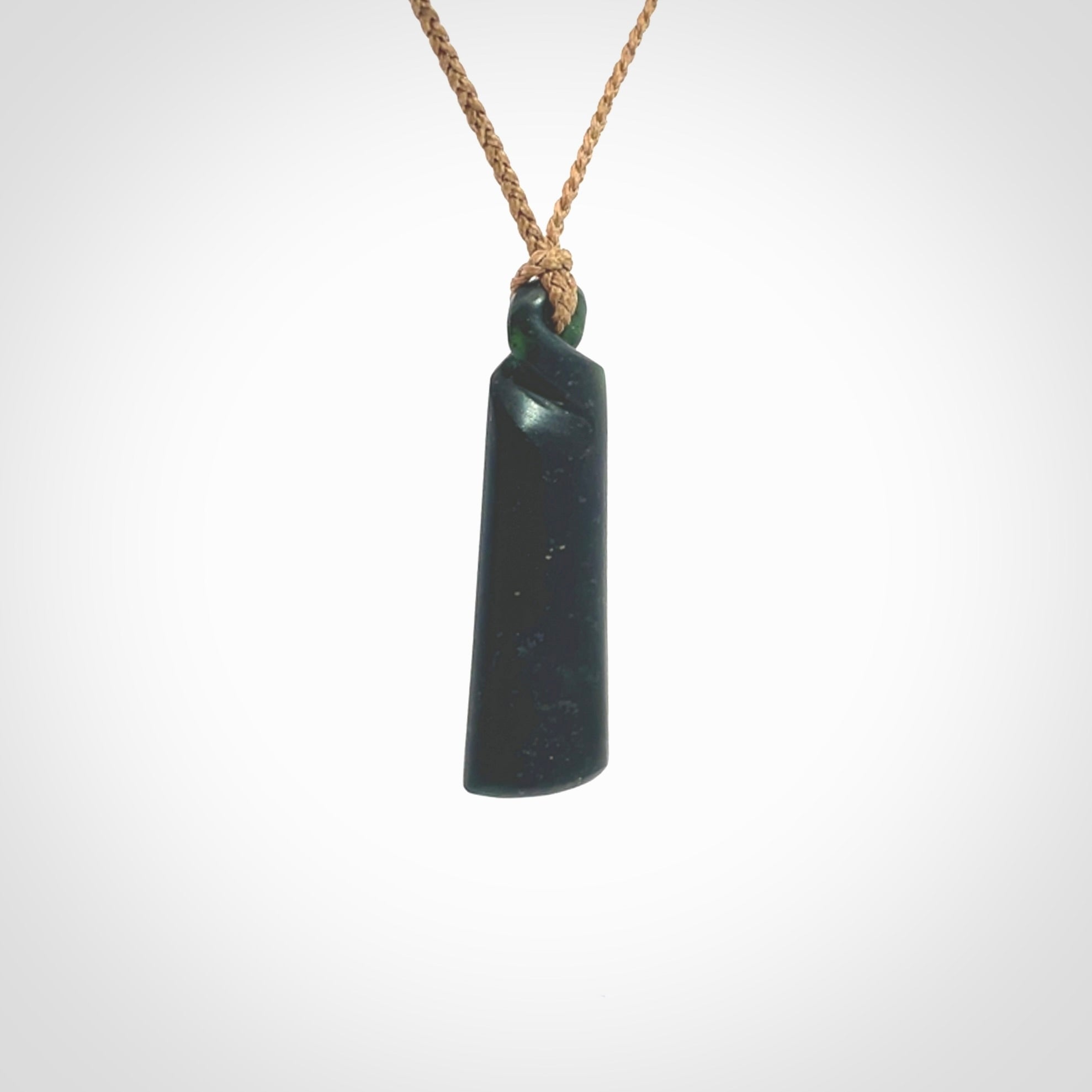 This pendant is a New Zealand jade single twist. It is hand carved from New Zealand Pounamu and has a mix of green, mint and pale colours interspersed throughout the stone. It has a fine twist, small and light. The cord is hand plaited and can be adjusted.