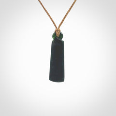 This pendant is a New Zealand jade single twist. It is hand carved from New Zealand Pounamu and has a mix of green, mint and pale colours interspersed throughout the stone. It has a fine twist, small and light. The cord is hand plaited and can be adjusted.