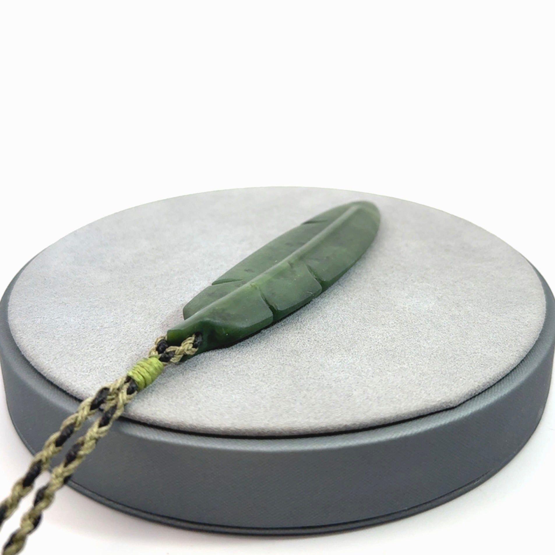 A hand carved large New Zealand Jade feather necklace. The cord is a black/khaki colour and is adjustable. A large sized hand made Jade feather necklace by New Zealand artist Kerry Thompson. One off work of art to wear.