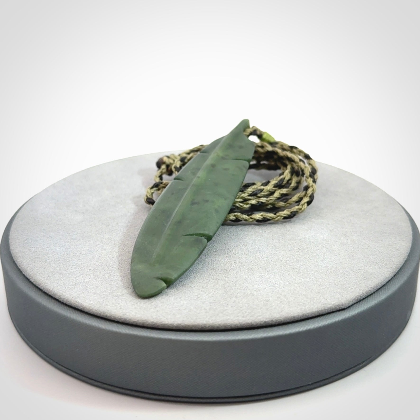 A hand carved large New Zealand Jade feather necklace. The cord is a black/khaki colour and is adjustable. A large sized hand made Jade feather necklace by New Zealand artist Kerry Thompson. One off work of art to wear.