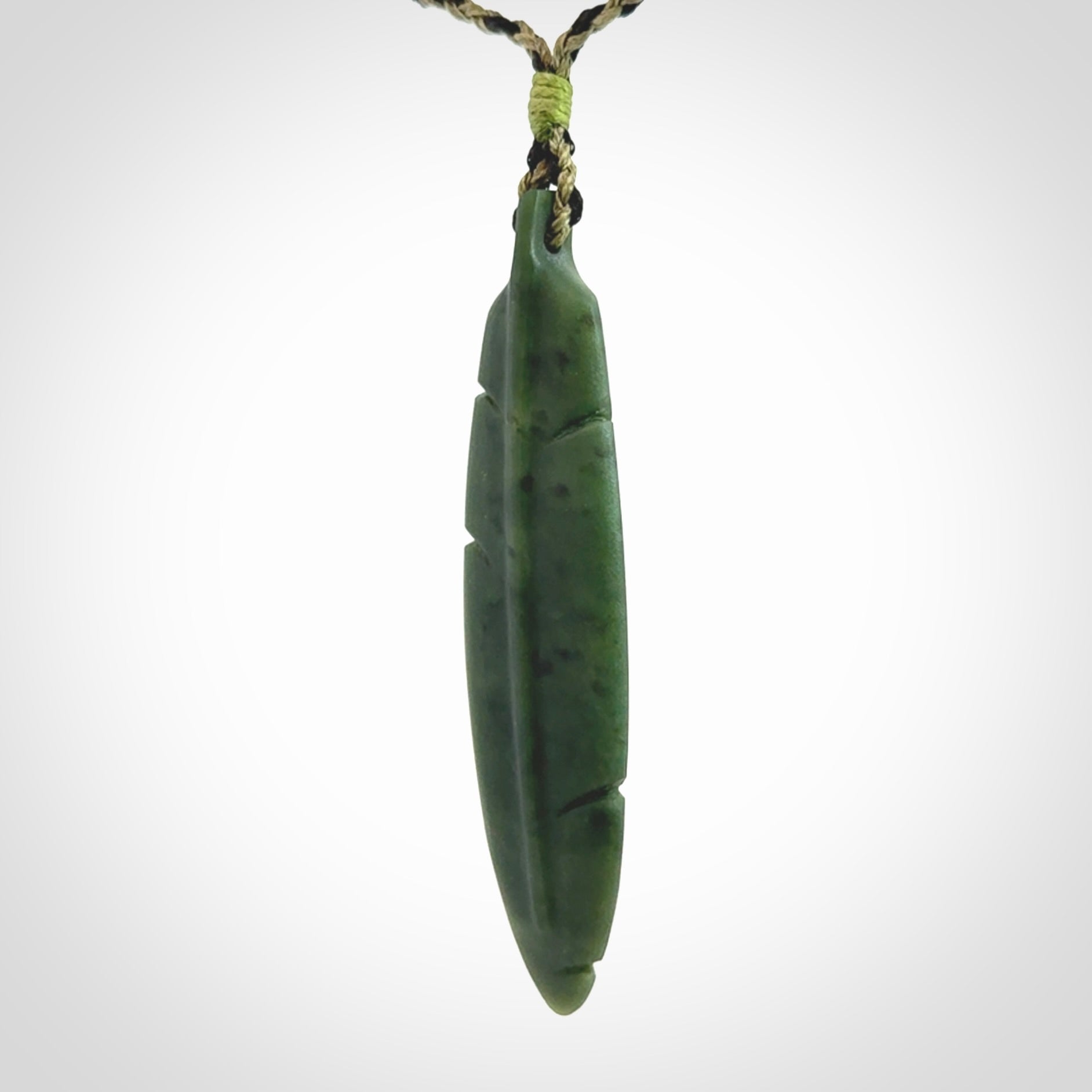A hand carved large New Zealand Jade feather necklace. The cord is a black/khaki colour and is adjustable. A large sized hand made Jade feather necklace by New Zealand artist Kerry Thompson. One off work of art to wear.