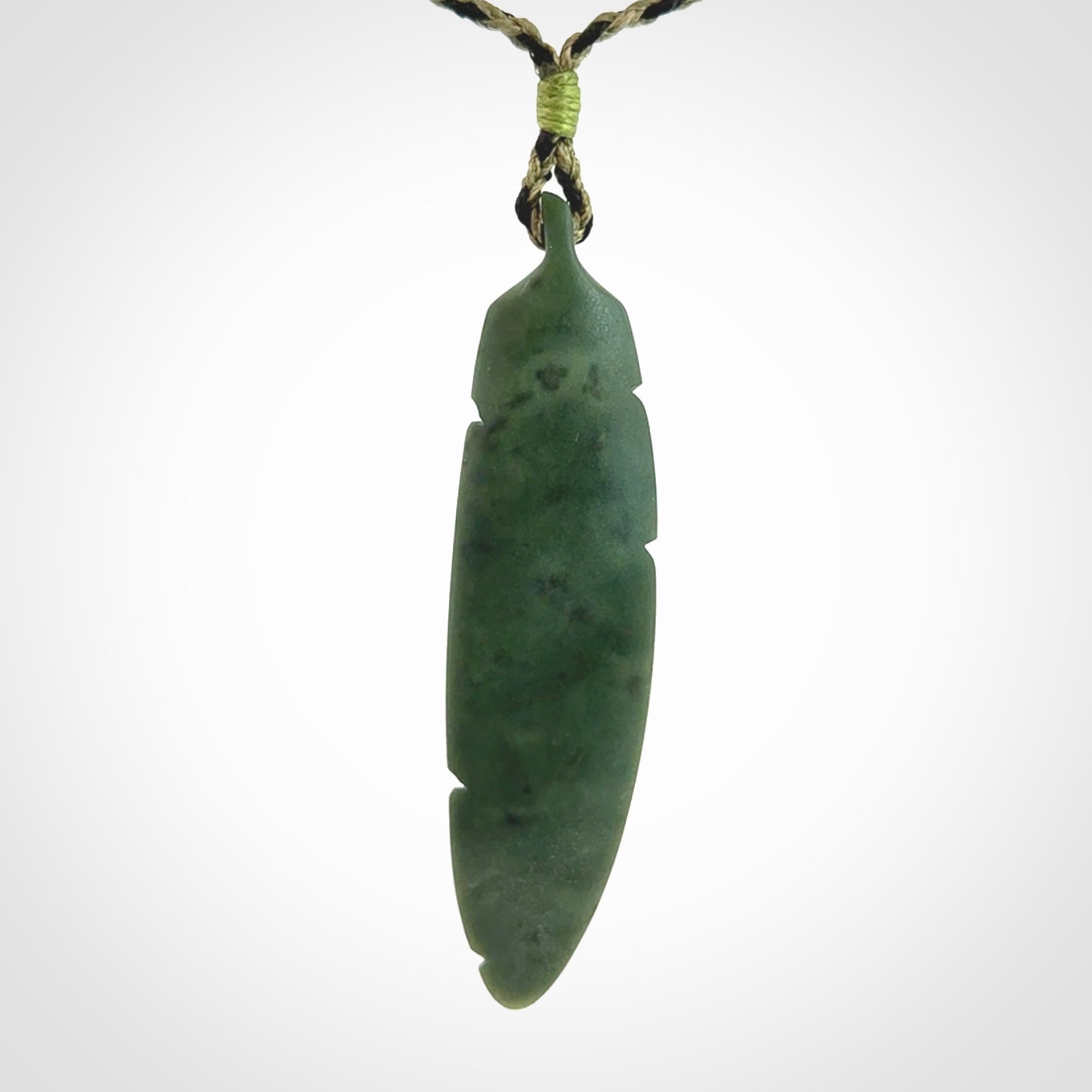 A hand carved large New Zealand Jade feather necklace. The cord is a black/khaki colour and is adjustable. A large sized hand made Jade feather necklace by New Zealand artist Kerry Thompson. One off work of art to wear.