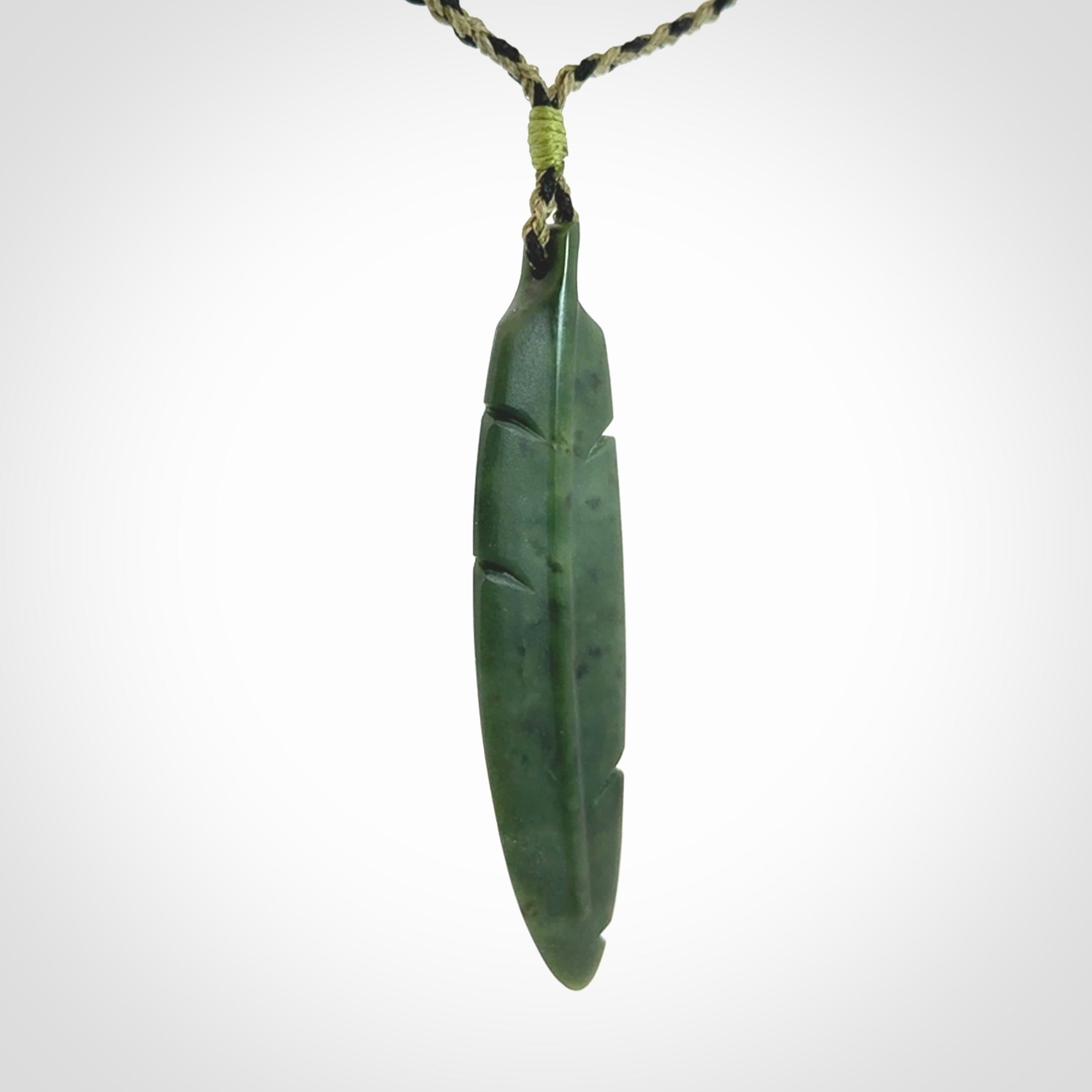 A hand carved large New Zealand Jade feather necklace. The cord is a black/khaki colour and is adjustable. A large sized hand made Jade feather necklace by New Zealand artist Kerry Thompson. One off work of art to wear.