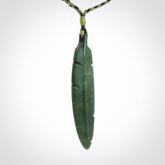 A hand carved large New Zealand Jade feather necklace. The cord is a black/khaki colour and is adjustable. A large sized hand made Jade feather necklace by New Zealand artist Kerry Thompson. One off work of art to wear.
