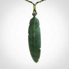 A hand carved large New Zealand Jade feather necklace. The cord is a black/khaki colour and is adjustable. A large sized hand made Jade feather necklace by New Zealand artist Kerry Thompson. One off work of art to wear.