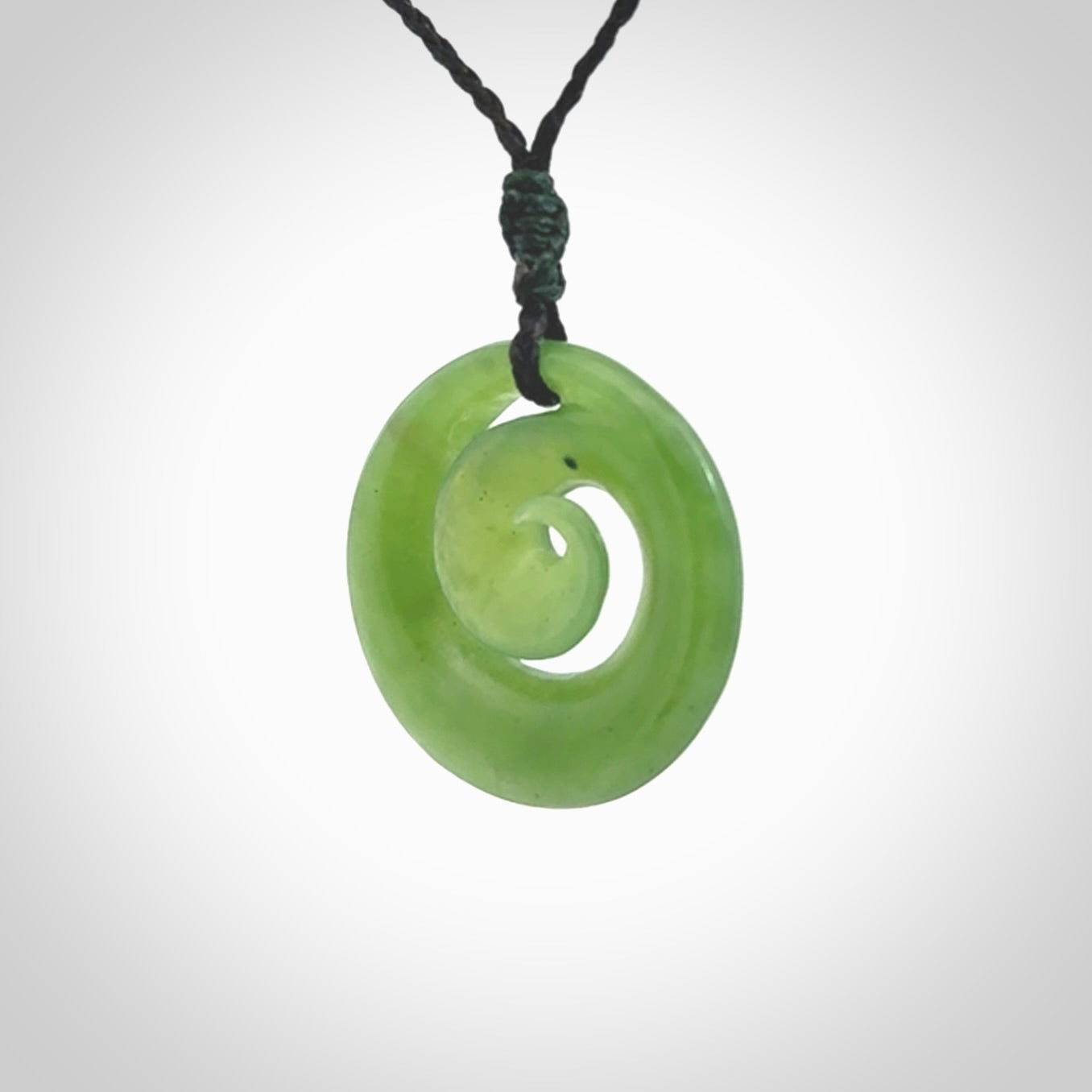 Hand carved New Zealand Kawakawa jade koru pendant. Carved for NZ Pacific by Ross Crump. Jade jewelry for sale online exclusively with NZ Pacific.