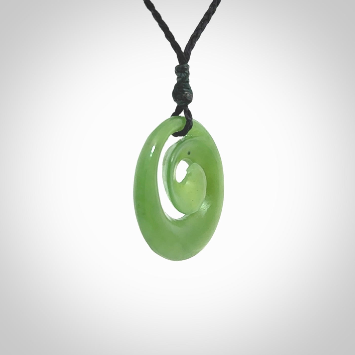 Hand carved New Zealand Kawakawa jade koru pendant. Carved for NZ Pacific by Ross Crump. Jade jewelry for sale online exclusively with NZ Pacific.