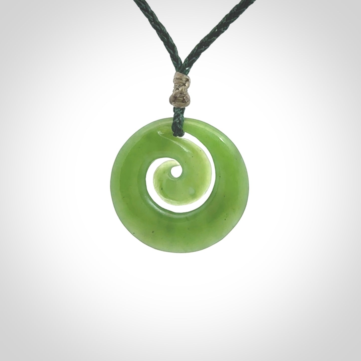 Hand carved New Zealand Kawakawa jade koru pendant. Carved for NZ Pacific by Ross Crump. Jade jewelry for sale online exclusively with NZ Pacific.
