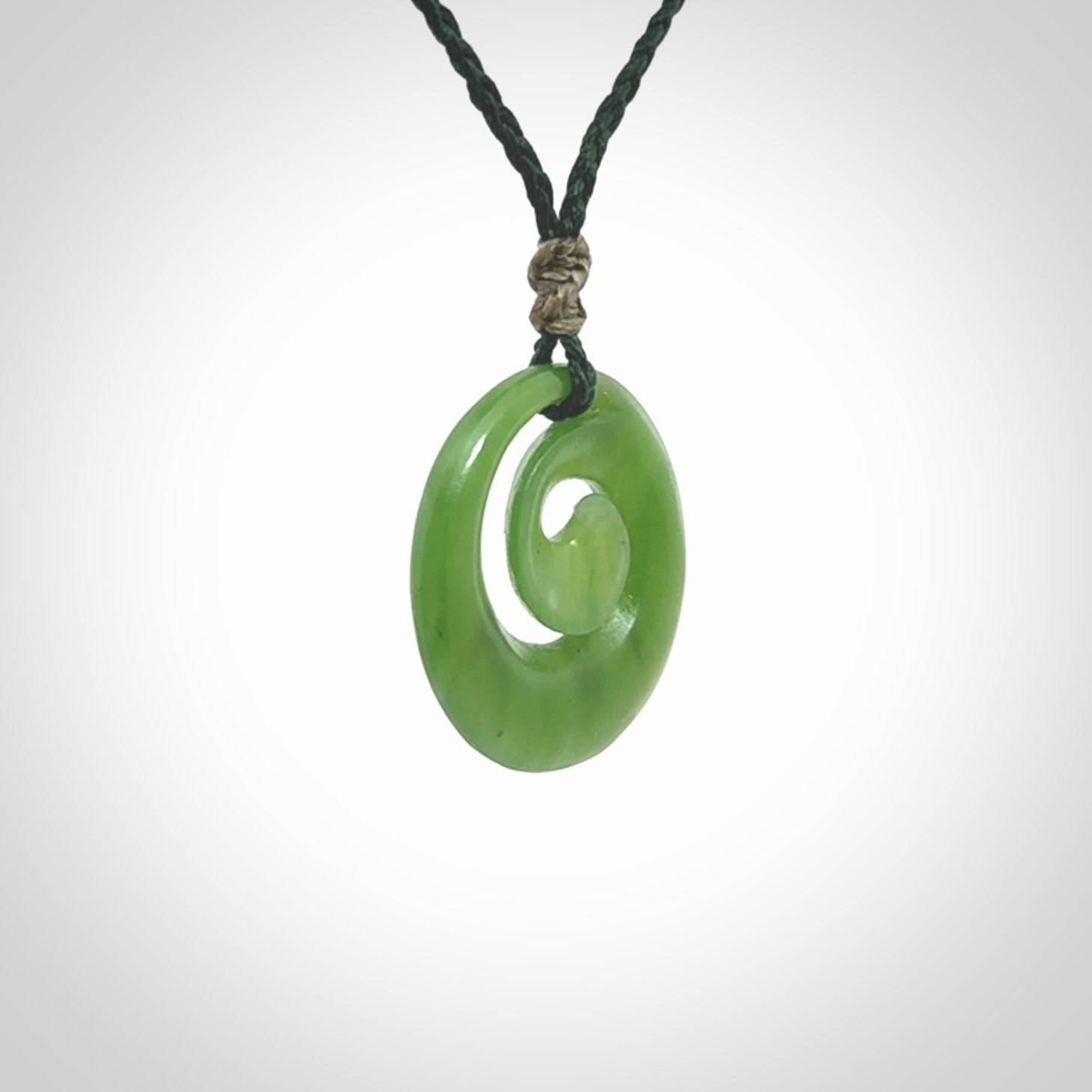 Hand carved New Zealand Kawakawa jade koru pendant. Carved for NZ Pacific by Ross Crump. Jade jewelry for sale online exclusively with NZ Pacific.