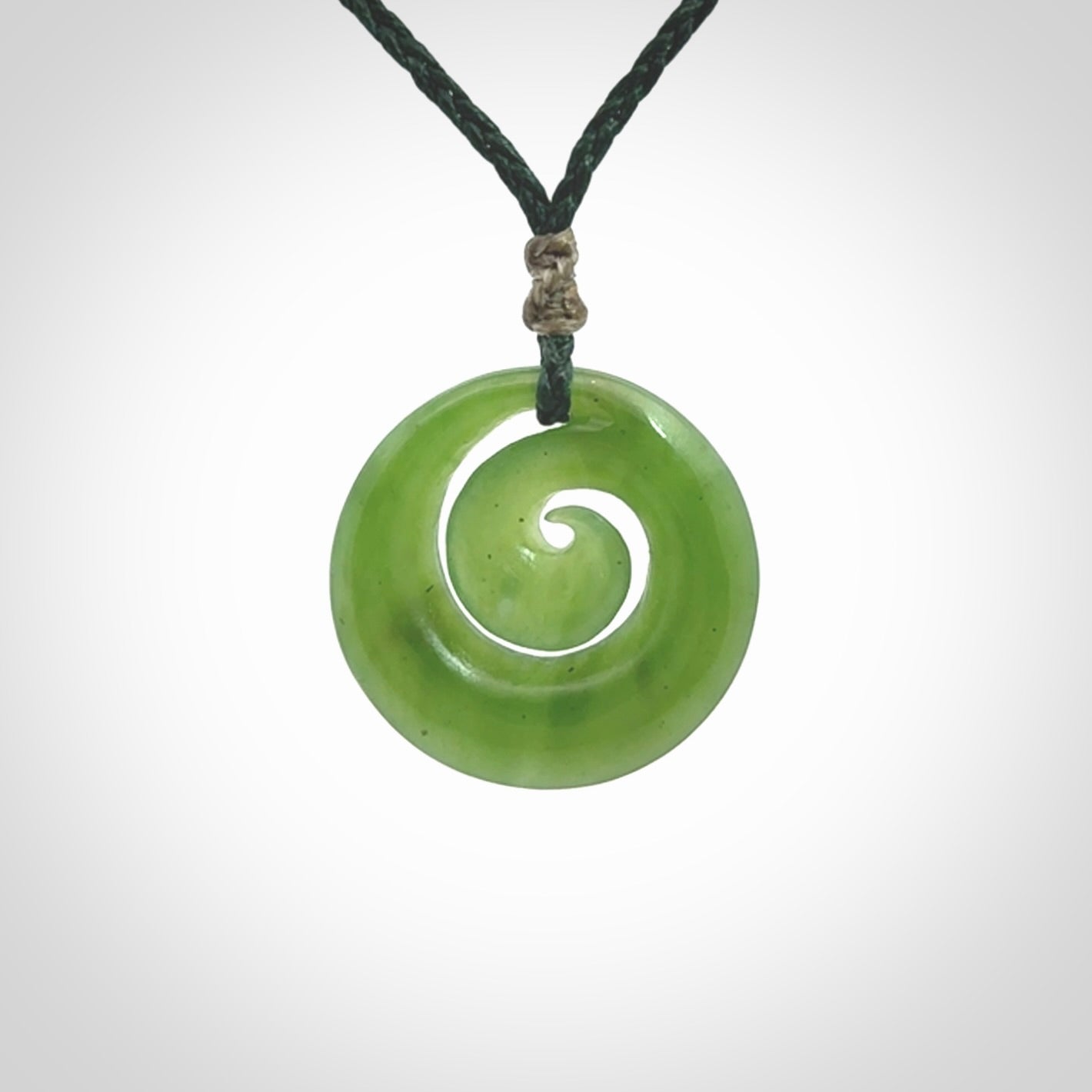 Hand carved New Zealand Kawakawa jade koru pendant. Carved for NZ Pacific by Ross Crump. Jade jewelry for sale online exclusively with NZ Pacific.