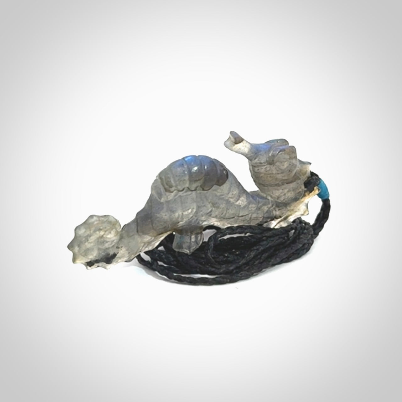 A hand carved labradorite seahorse pendant. We have carved this from beautiful labradorite and we bind them with our hand-plaited cords. The cords are a waxed polyester so they are durable and strong. We ship these worldwide with express courier anywhere in the world.