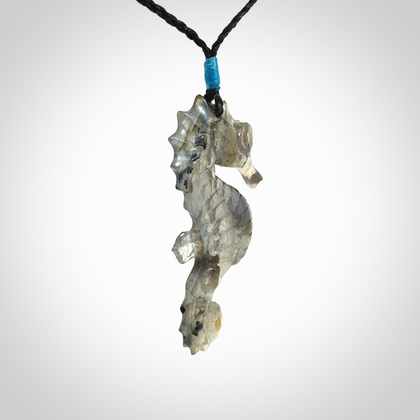 A hand carved labradorite seahorse pendant. We have carved this from beautiful labradorite and we bind them with our hand-plaited cords. The cords are a waxed polyester so they are durable and strong. We ship these worldwide with express courier anywhere in the world.