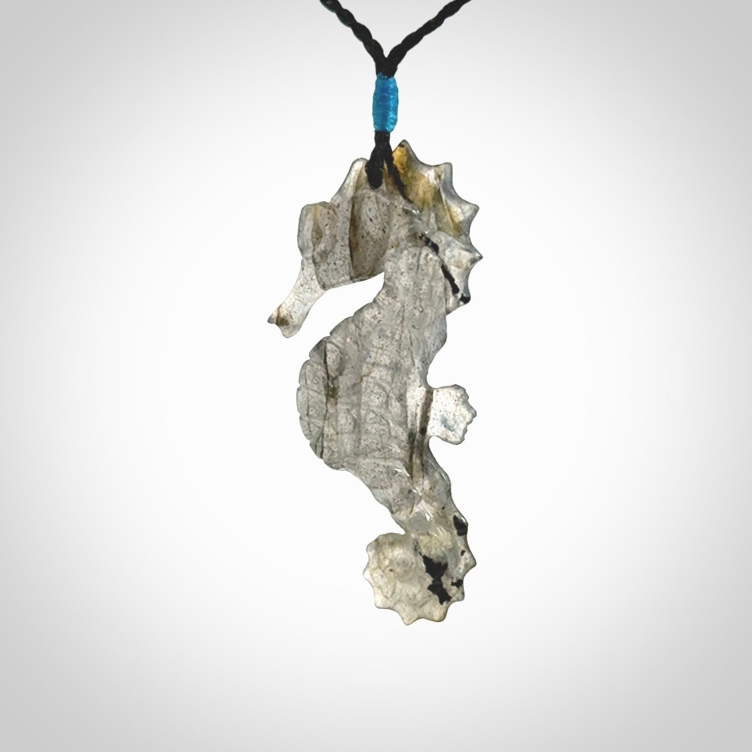A hand carved labradorite seahorse pendant. We have carved this from beautiful labradorite and we bind them with our hand-plaited cords. The cords are a waxed polyester so they are durable and strong. We ship these worldwide with express courier anywhere in the world.