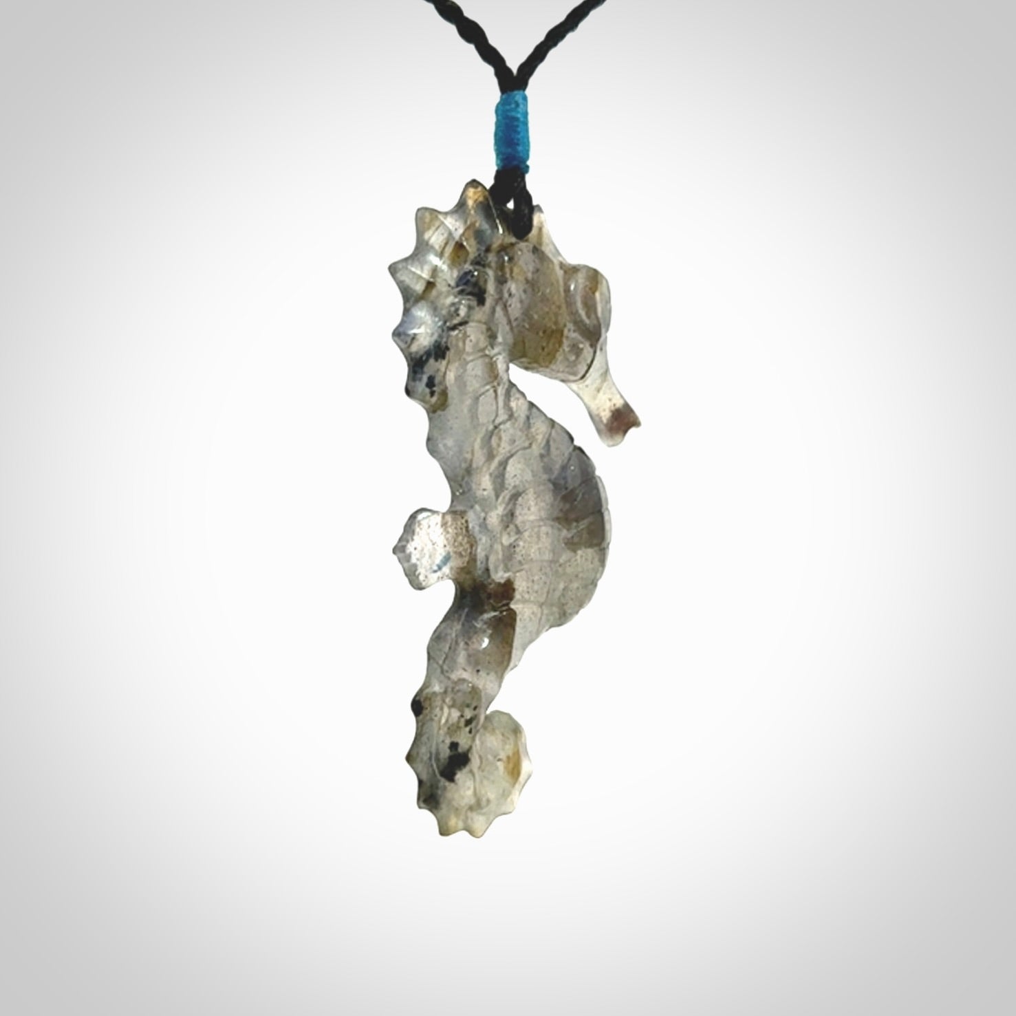 A hand carved labradorite seahorse pendant. We have carved this from beautiful labradorite and we bind them with our hand-plaited cords. The cords are a waxed polyester so they are durable and strong. We ship these worldwide with express courier anywhere in the world.