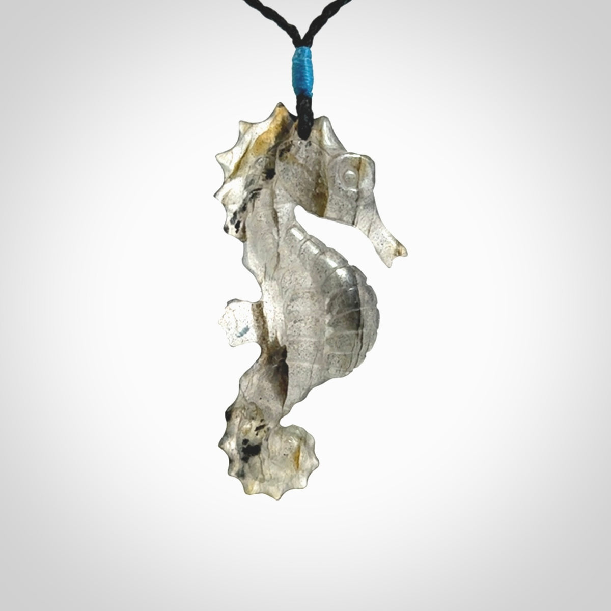 A hand carved labradorite seahorse pendant. We have carved this from beautiful labradorite and we bind them with our hand-plaited cords. The cords are a waxed polyester so they are durable and strong. We ship these worldwide with express courier anywhere in the world.