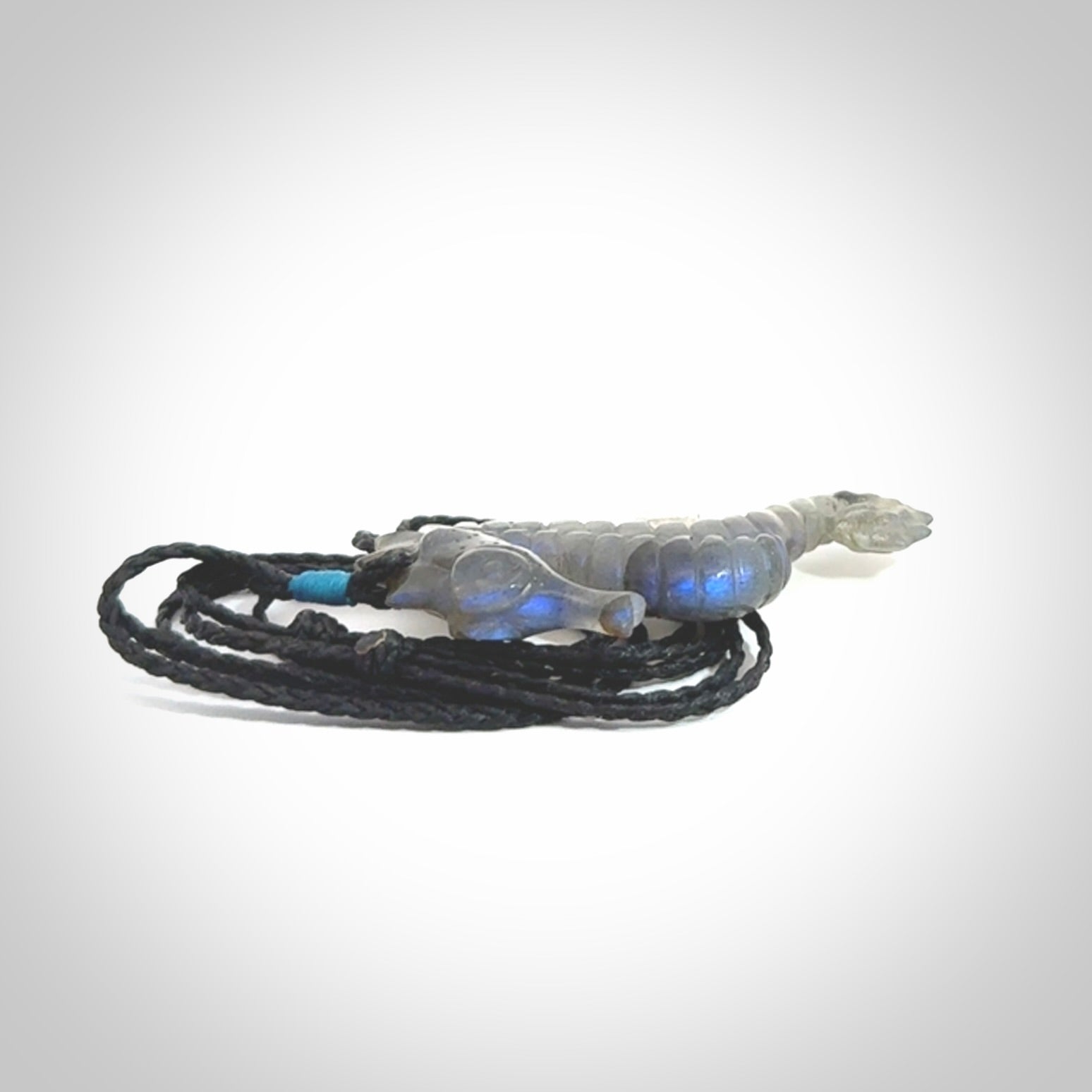 A hand carved labradorite seahorse pendant. We have carved this from beautiful labradorite and we bind them with our hand-plaited cords. The cords are a waxed polyester so they are durable and strong. We ship these worldwide with express courier anywhere in the world.
