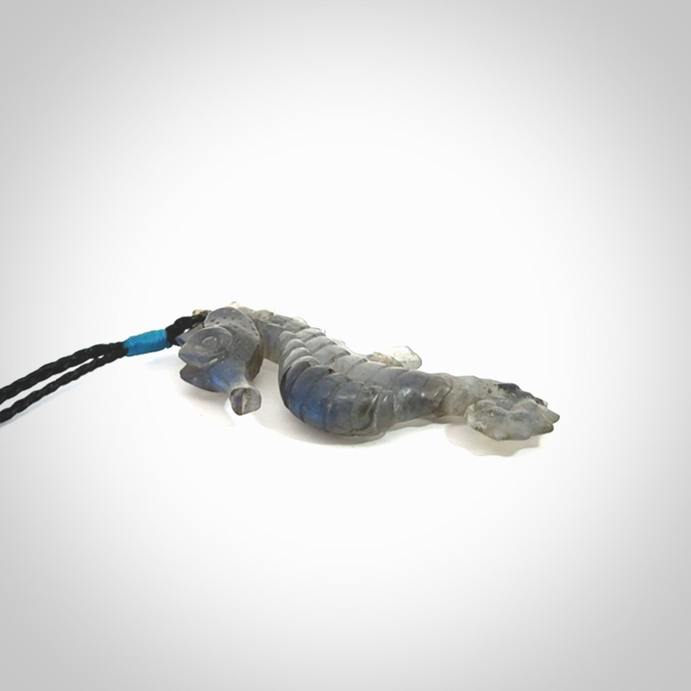 A hand carved labradorite seahorse pendant. We have carved this from beautiful labradorite and we bind them with our hand-plaited cords. The cords are a waxed polyester so they are durable and strong. We ship these worldwide with express courier anywhere in the world.