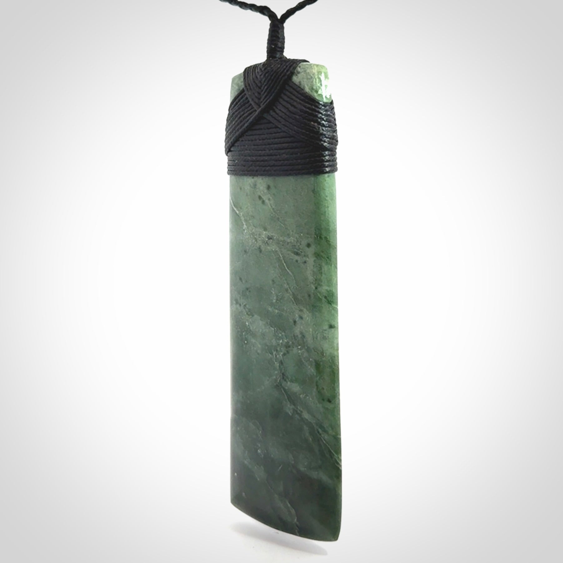 A large and beautiful hand carved toki pendant. This piece is carved from New Zealand jade by NZ Pacific. This is a wonderful large toki bound with a hand-plaited black cord and a traditional black lashing. A beautiful, traditional toki for sale online.