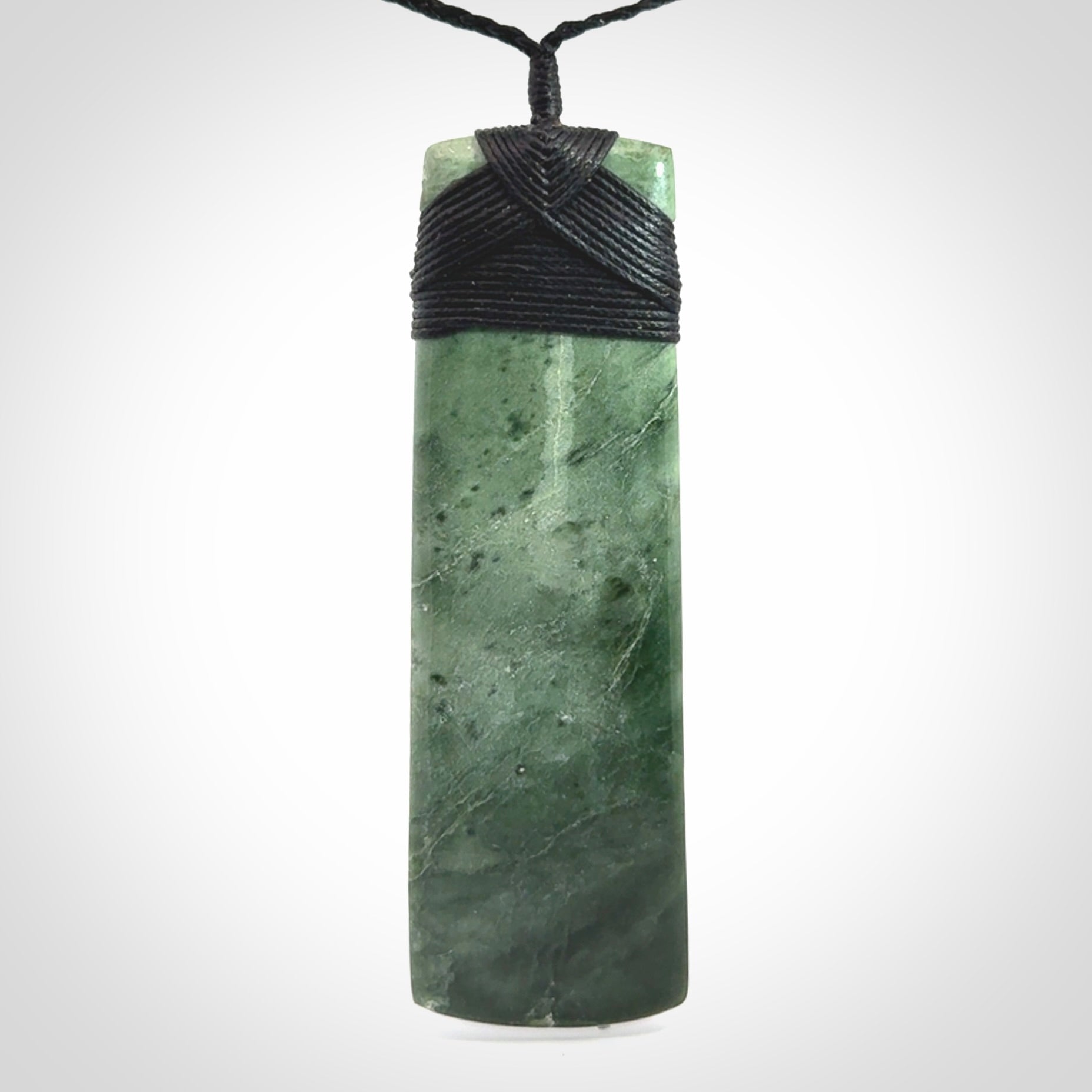 A large and beautiful hand carved toki pendant. This piece is carved from New Zealand jade by NZ Pacific. This is a wonderful large toki bound with a hand-plaited black cord and a traditional black lashing. A beautiful, traditional toki for sale online.