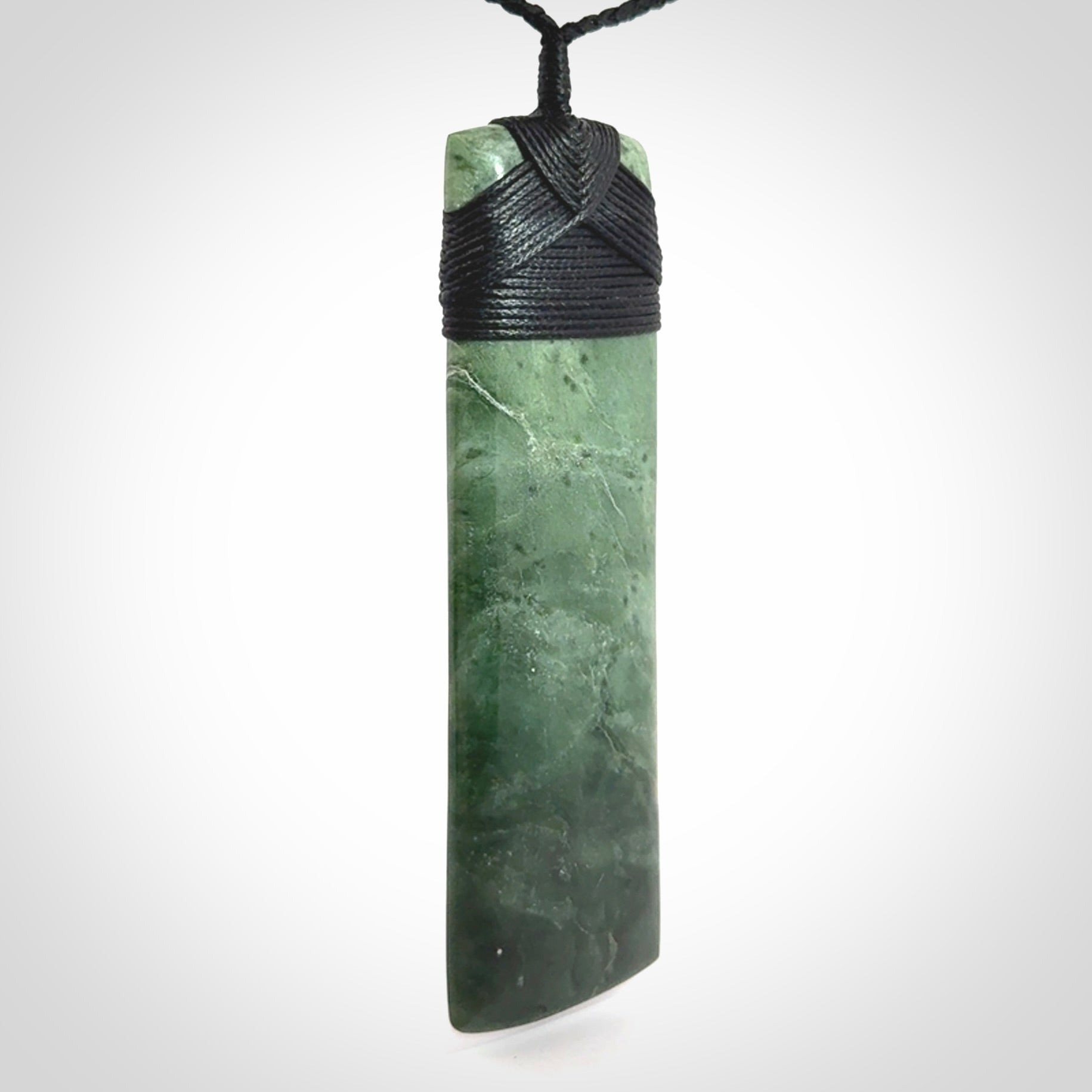 A large and beautiful hand carved toki pendant. This piece is carved from New Zealand jade by NZ Pacific. This is a wonderful large toki bound with a hand-plaited black cord and a traditional black lashing. A beautiful, traditional toki for sale online.