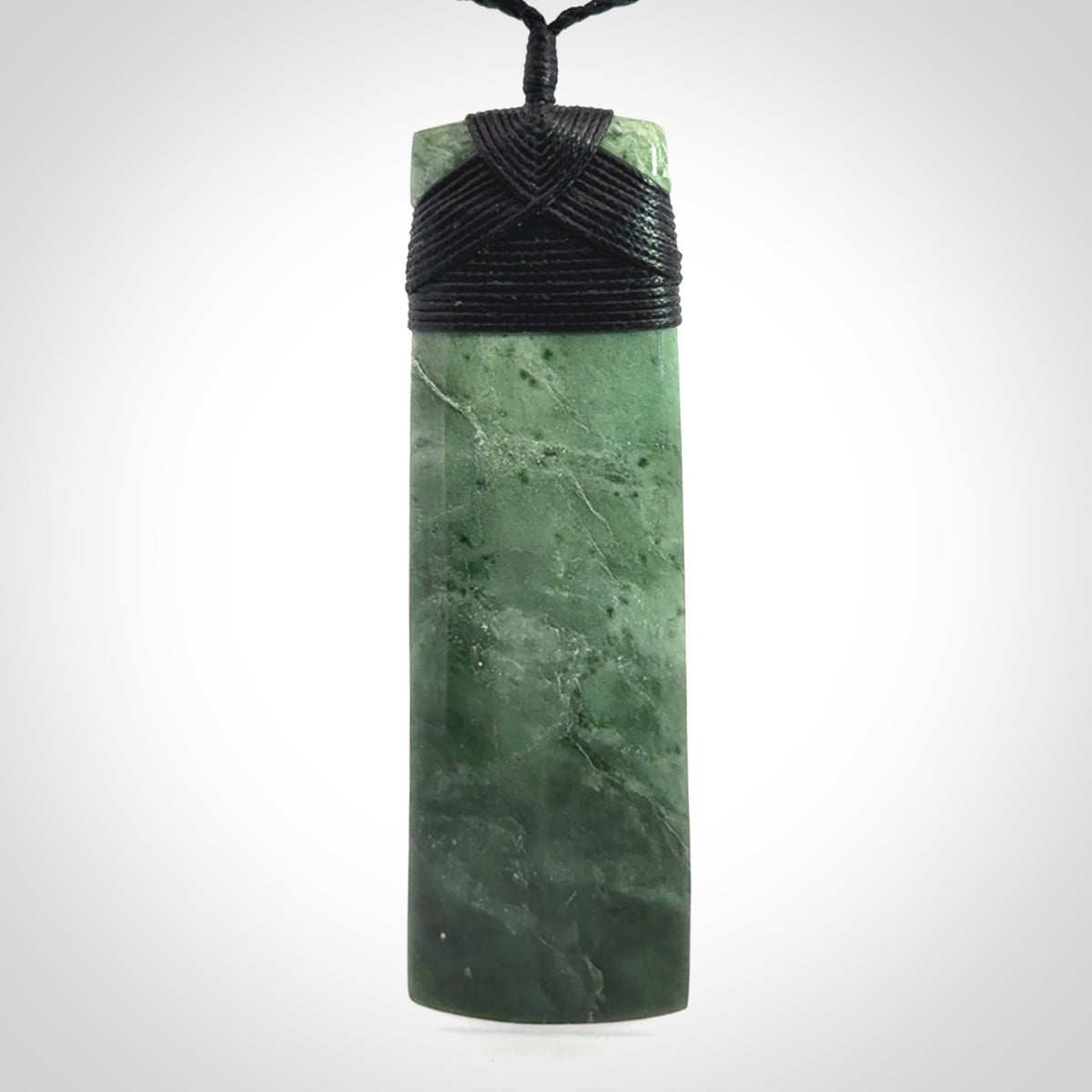 A large and beautiful hand carved toki pendant. This piece is carved from New Zealand jade by NZ Pacific. This is a wonderful large toki bound with a hand-plaited black cord and a traditional black lashing. A beautiful, traditional toki for sale online.