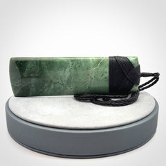 A large and beautiful hand carved toki pendant. This piece is carved from New Zealand jade by NZ Pacific. This is a wonderful large toki bound with a hand-plaited black cord and a traditional black lashing. A beautiful, traditional toki for sale online.