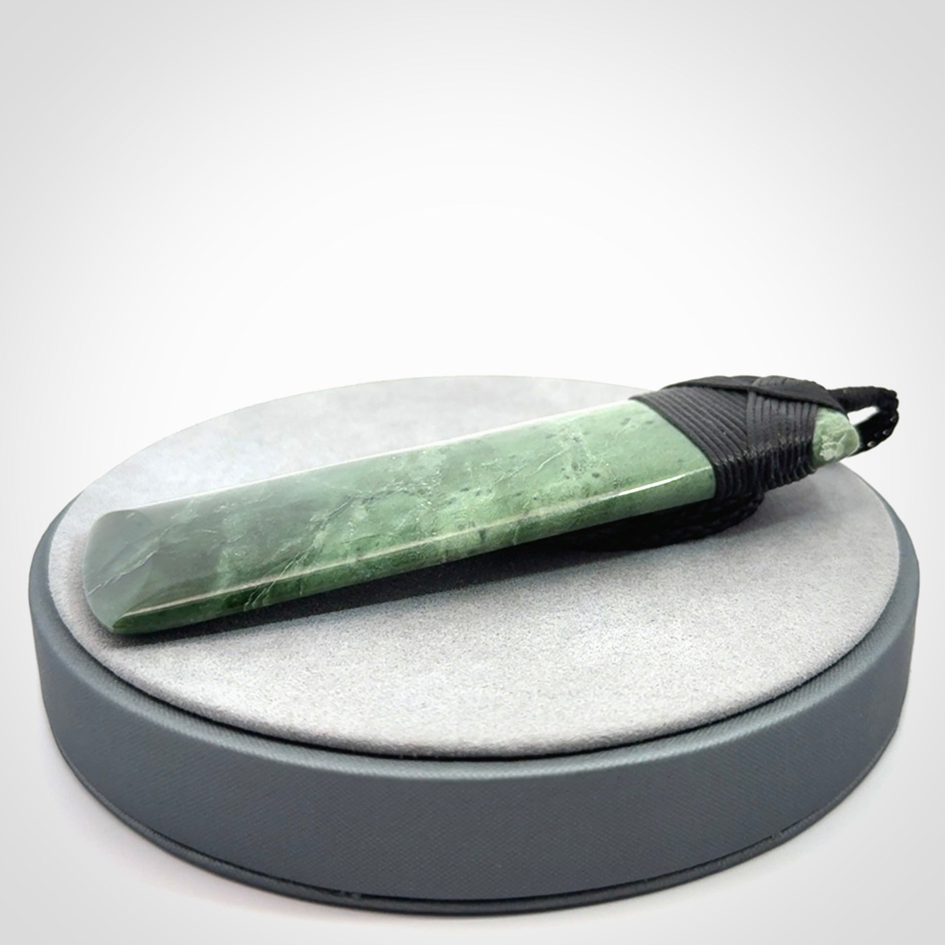A large and beautiful hand carved toki pendant. This piece is carved from New Zealand jade by NZ Pacific. This is a wonderful large toki bound with a hand-plaited black cord and a traditional black lashing. A beautiful, traditional toki for sale online.