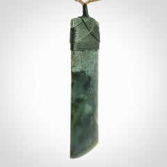 A large and beautiful hand carved toki pendant. This piece is carved from New Zealand jade by NZ Pacific. This is a wonderful large toki bound with a tan cord and a traditional sage green lashing. A beautiful, traditional toki for sale online.
