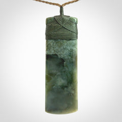 A large and beautiful hand carved toki pendant. This piece is carved from New Zealand jade by NZ Pacific. This is a wonderful large toki bound with a tan cord and a traditional sage green lashing. A beautiful, traditional toki for sale online.