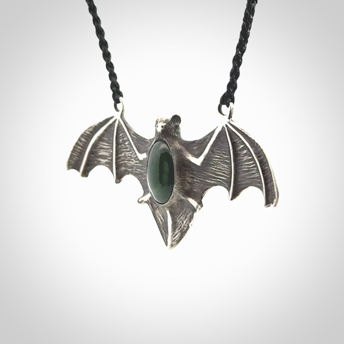 This is a hand carved bat pendant. It is made from New Zealand Jade and Sterling Silver. This is a medium sized necklace and is a very unique, one only, pendant that is a collectors piece. Provided with black adjustable cord.