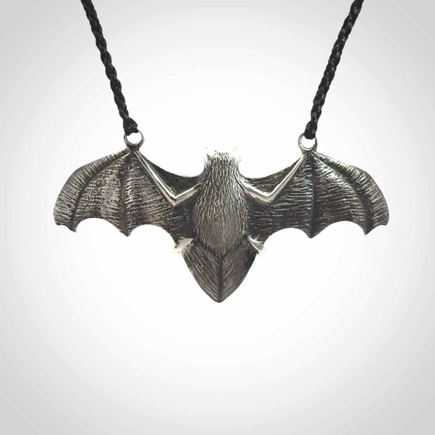 This is a hand carved bat pendant. It is made from New Zealand Jade and Sterling Silver. This is a medium sized necklace and is a very unique, one only, pendant that is a collectors piece. Provided with black adjustable cord.