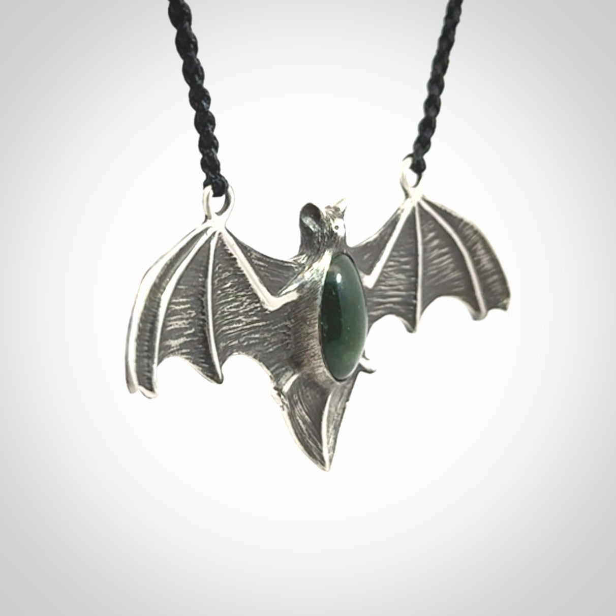 This is a hand carved bat pendant. It is made from New Zealand Jade and Sterling Silver. This is a medium sized necklace and is a very unique, one only, pendant that is a collectors piece. Provided with black adjustable cord.