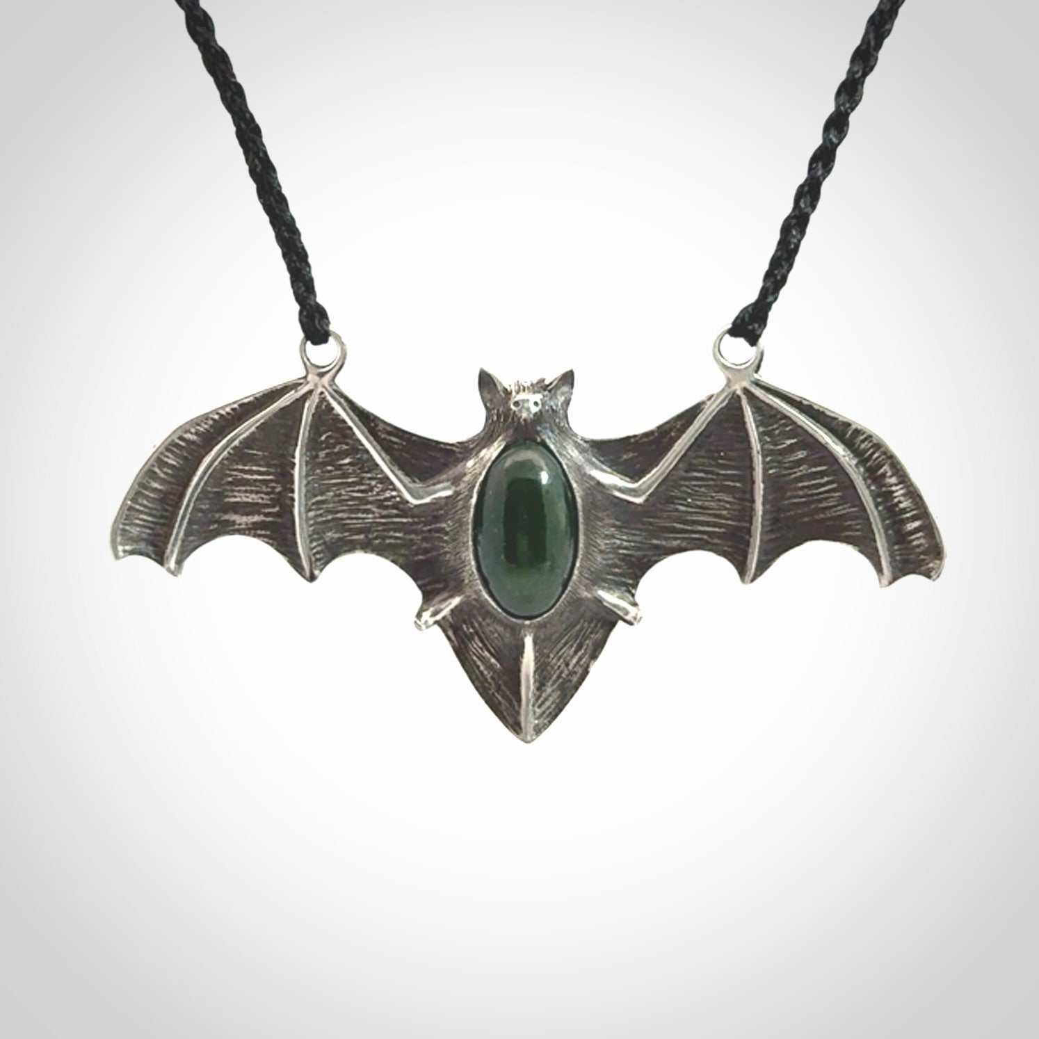This is a hand carved bat pendant. It is made from New Zealand Jade and Sterling Silver. This is a medium sized necklace and is a very unique, one only, pendant that is a collectors piece. Provided with black adjustable cord.