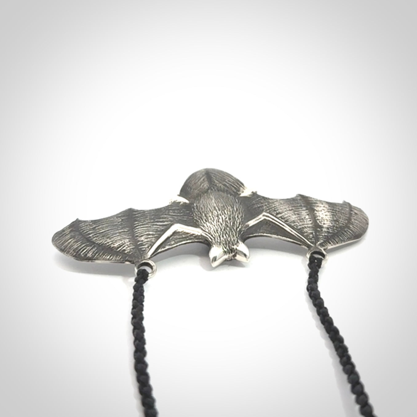 This is a hand carved bat pendant. It is made from New Zealand Jade and Sterling Silver. This is a medium sized necklace and is a very unique, one only, pendant that is a collectors piece. Provided with black adjustable cord.