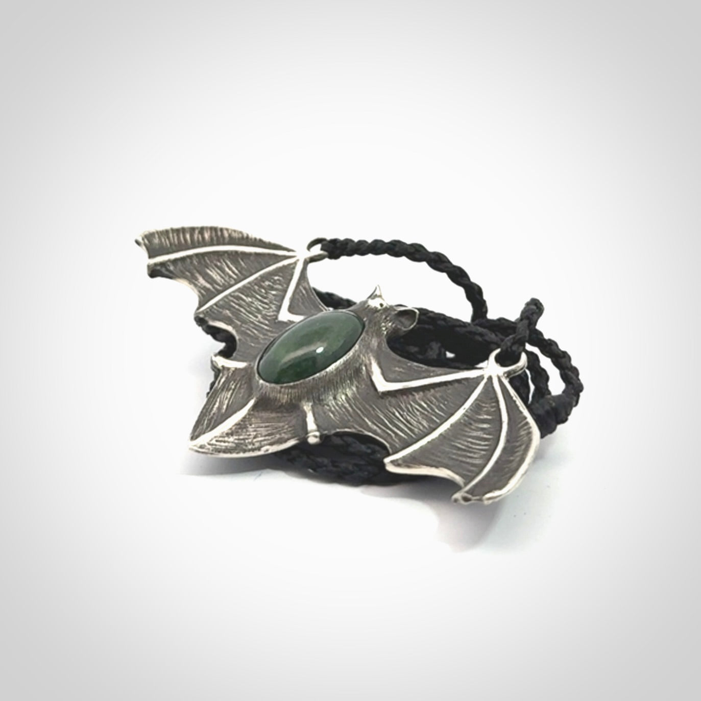 This is a hand carved bat pendant. It is made from New Zealand Jade and Sterling Silver. This is a medium sized necklace and is a very unique, one only, pendant that is a collectors piece. Provided with black adjustable cord.